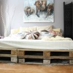 Homemade bed from construction Euro pallets in the bedroom interior